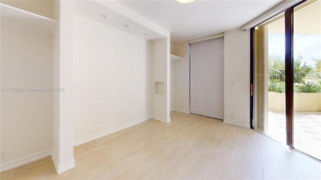 unfurnished room with light wood-type flooring and floor to ceiling windows