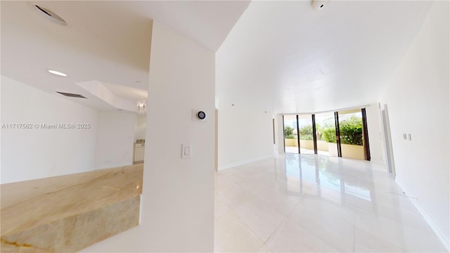 unfurnished room featuring a notable chandelier, floor to ceiling windows, and light tile patterned floors