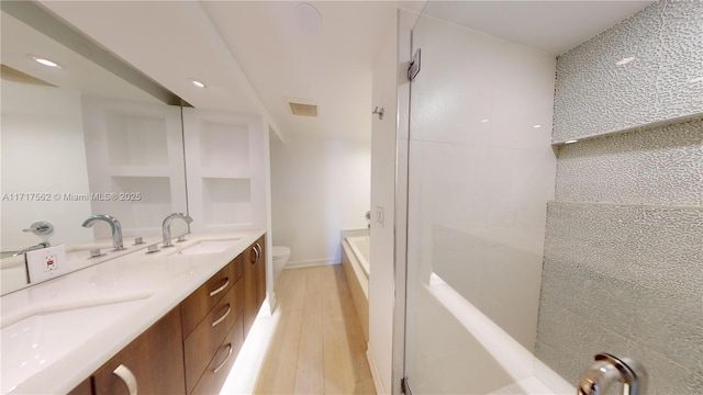 bathroom featuring a bathing tub, hardwood / wood-style floors, vanity, and toilet