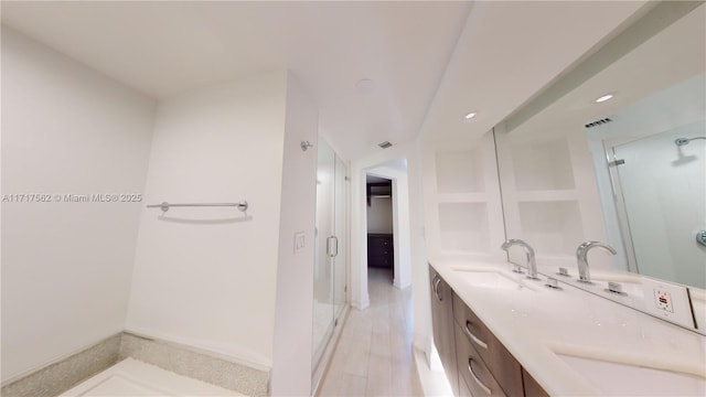 bathroom featuring vanity and an enclosed shower