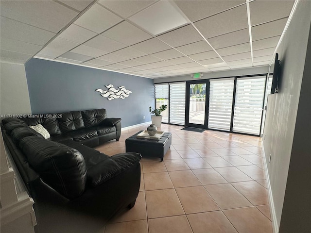 living room featuring light tile patterned floors and a drop ceiling