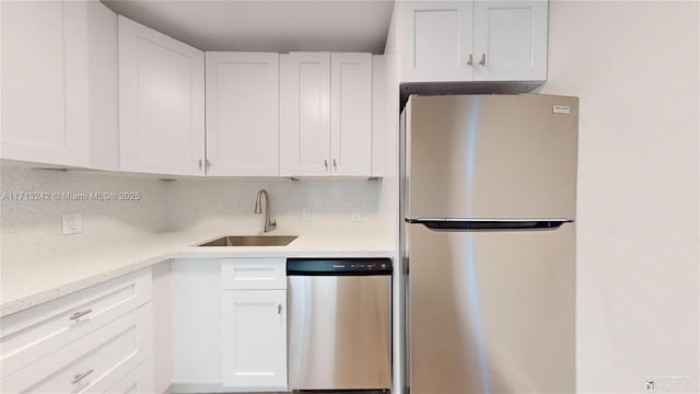 kitchen featuring white cabinetry, sink, backsplash, and stainless steel appliances