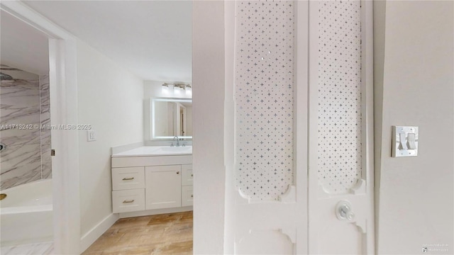 bathroom with vanity, hardwood / wood-style floors, and tiled shower / bath combo