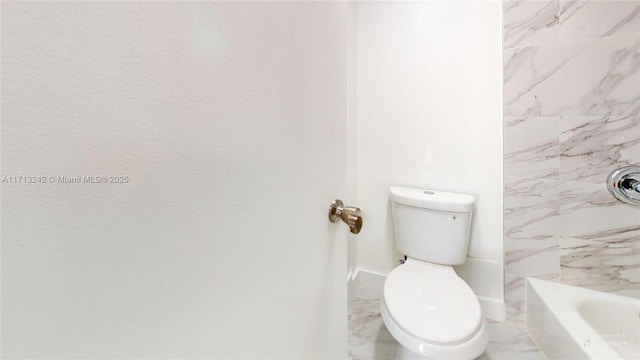 bathroom featuring a tub and toilet