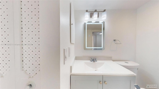 bathroom with vanity, toilet, and a shower