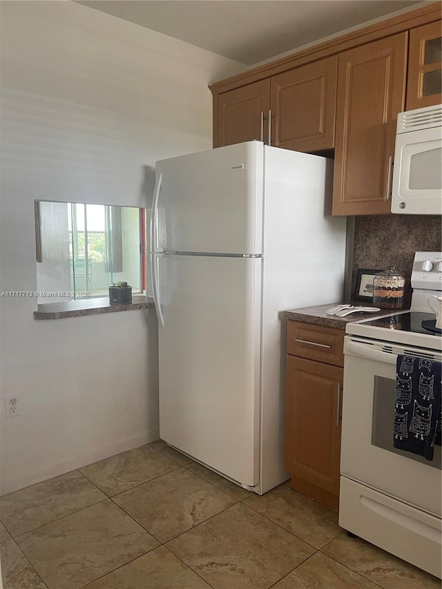 8345 Sunrise Lakes Blvd Unit 309, Sunrise, FL 33322 - kitchen with light tile patterned floors, tasteful backsplash, brown cabinets, and white appliances