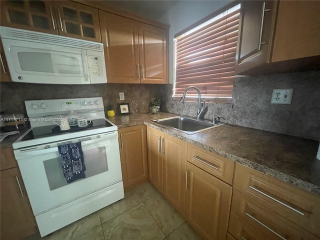 kitchen with backsplash, white appliances, and sink