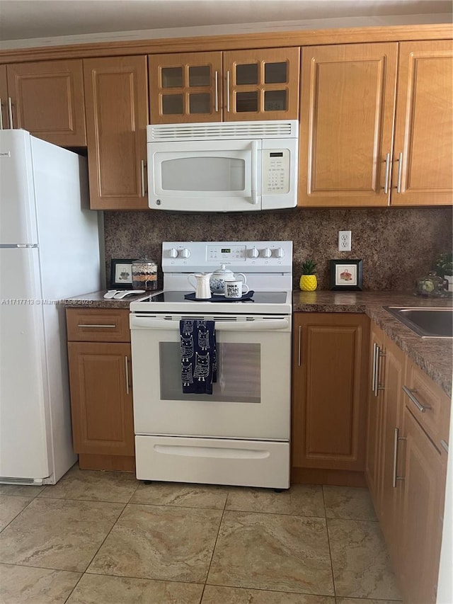 kitchen with tasteful backsplash, sink, light tile patterned floors, and white appliances