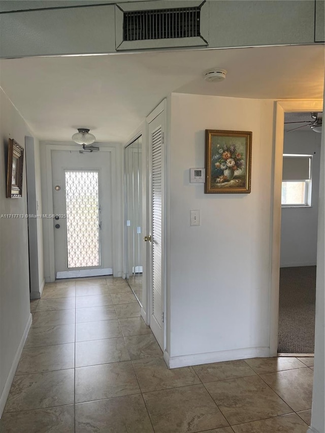 hallway featuring tile patterned floors and a healthy amount of sunlight