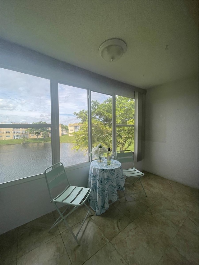 unfurnished sunroom featuring a water view