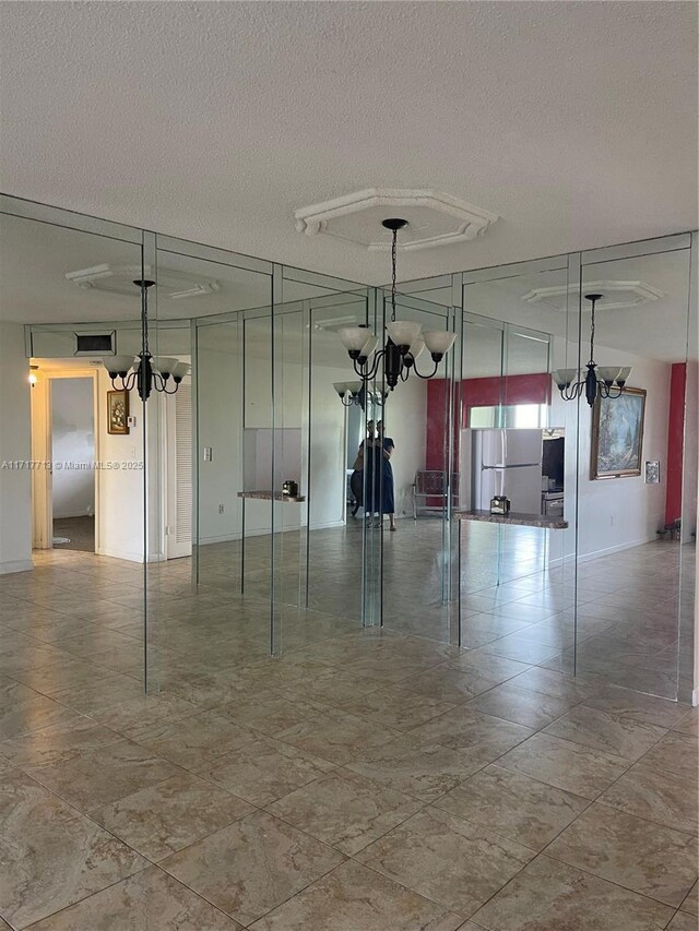 8345 Sunrise Lakes Blvd Unit 309, Sunrise, FL 33322 - spare room featuring a textured ceiling and an inviting chandelier