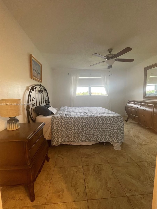 tiled bedroom featuring ceiling fan