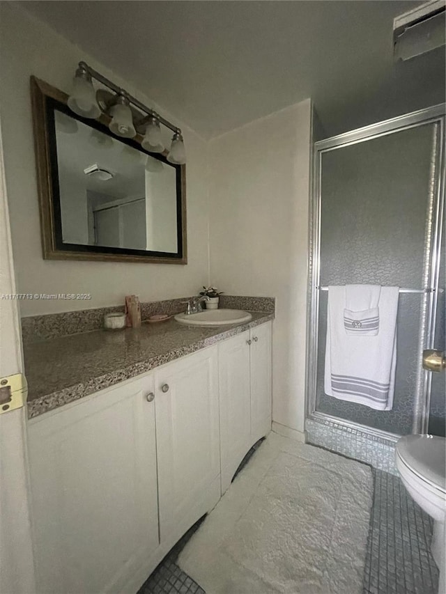 bathroom featuring vanity, an enclosed shower, and toilet