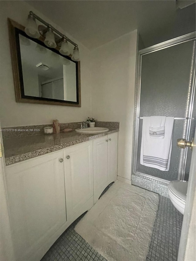 bathroom with tile patterned flooring, vanity, toilet, and walk in shower