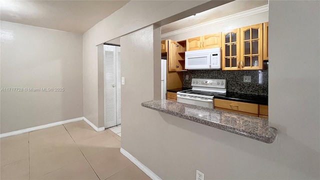 kitchen with tasteful backsplash, dark stone counters, white appliances, light brown cabinets, and light tile patterned flooring