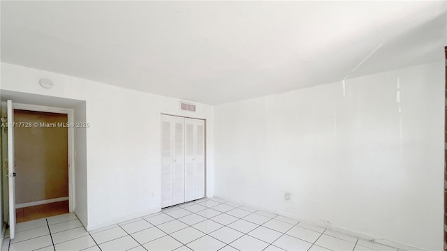 unfurnished bedroom featuring a closet and light tile patterned flooring