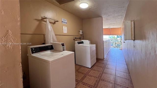 clothes washing area featuring independent washer and dryer and a textured ceiling