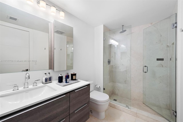 bathroom with tile patterned flooring, vanity, toilet, and a shower with door