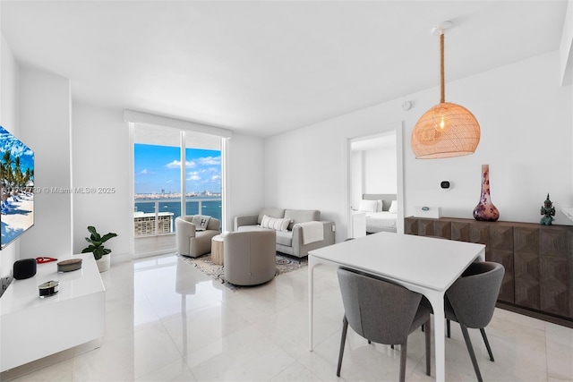 tiled dining room featuring a water view and a wall of windows