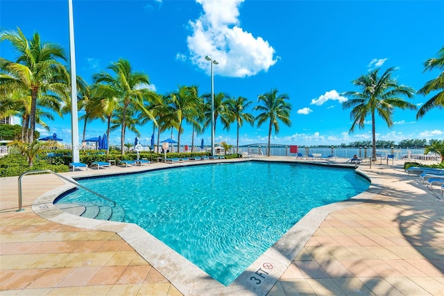 view of swimming pool with a water view and a patio area