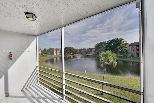 sunroom featuring a water view