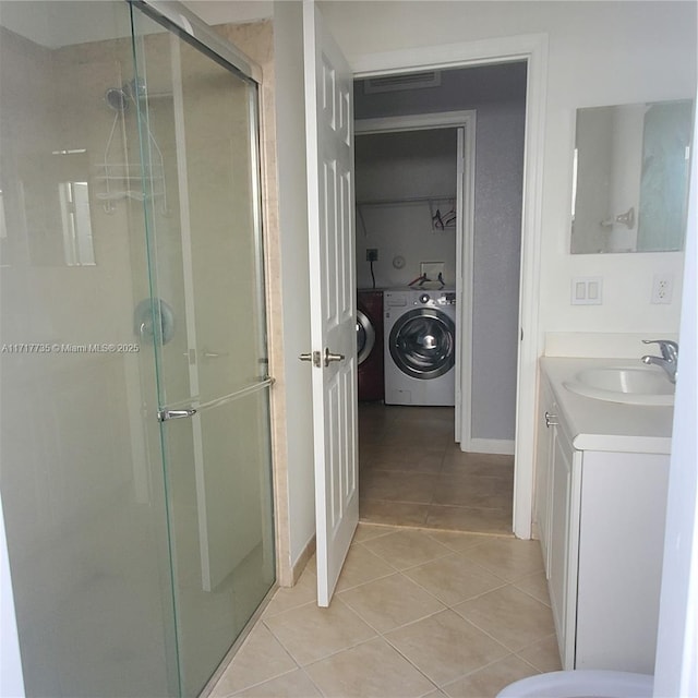 bathroom with tile patterned floors, washing machine and dryer, vanity, and walk in shower