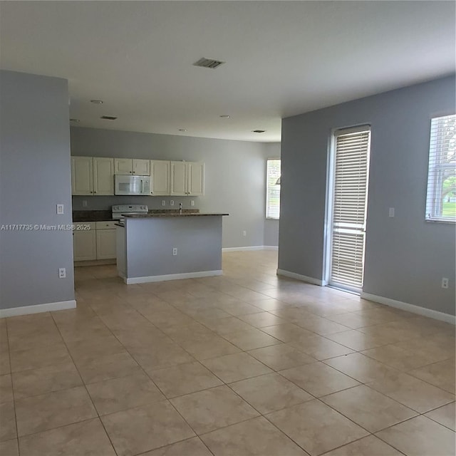 kitchen featuring light tile patterned flooring and white appliances