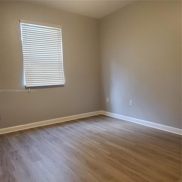 spare room with wood-type flooring