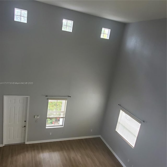 spare room with hardwood / wood-style flooring and a high ceiling