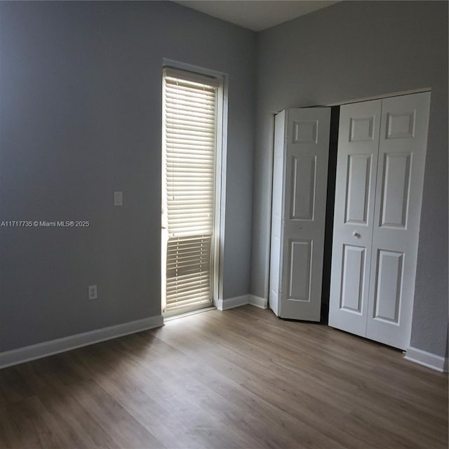 unfurnished bedroom with wood-type flooring and a closet