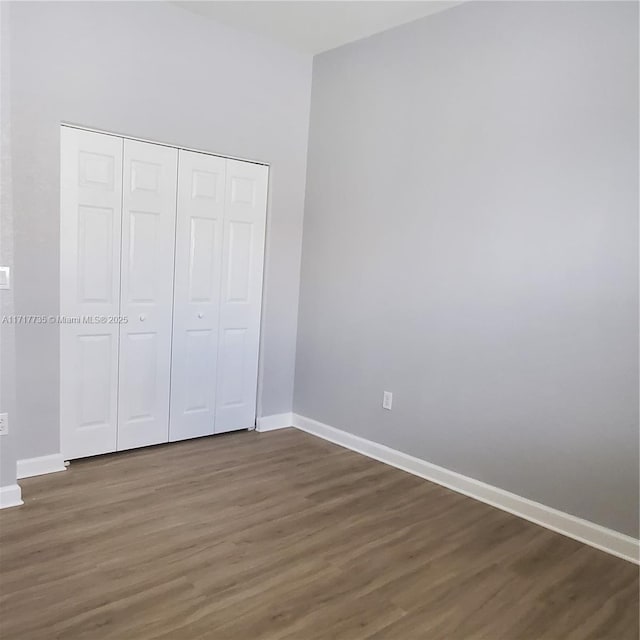 unfurnished bedroom featuring dark hardwood / wood-style flooring and a closet