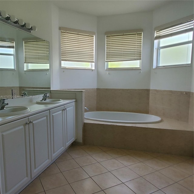 bathroom featuring tile patterned flooring, vanity, and tiled tub