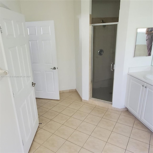 bathroom featuring tile patterned flooring, vanity, and a shower with door