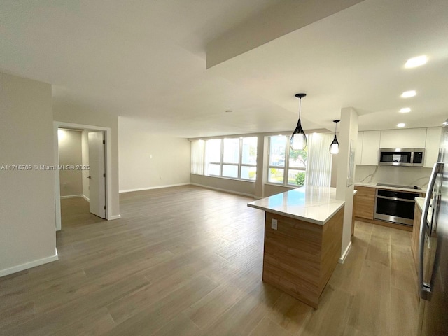 10230 Collins Ave Unit 102, Bal Harbour, FL 33154 - kitchen featuring stainless steel appliances, modern cabinets, light wood finished floors, white cabinetry, and light countertops
