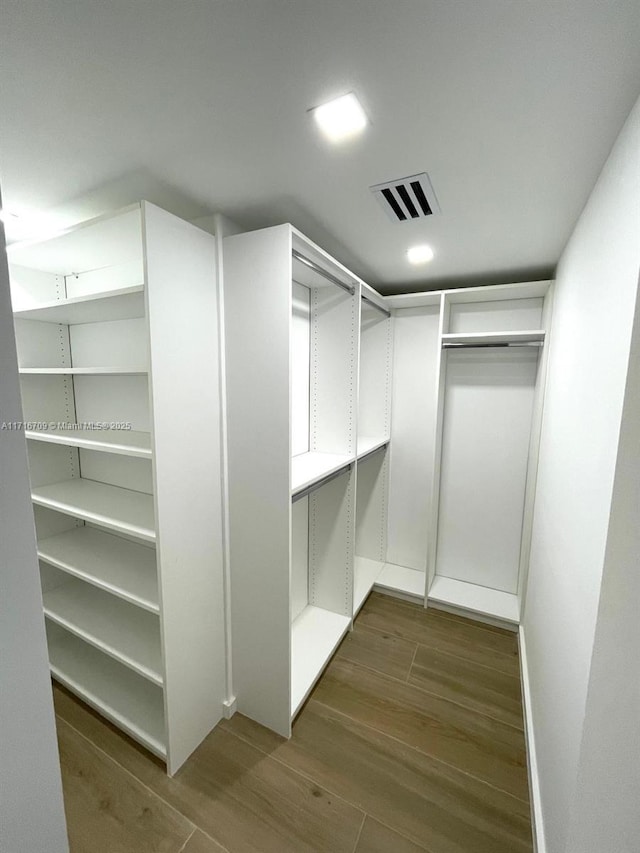 spacious closet featuring dark hardwood / wood-style floors