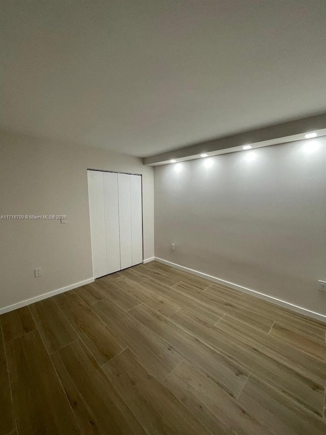 unfurnished bedroom with hardwood / wood-style floors and a closet