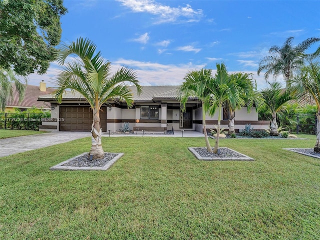 view of front of property with a garage and a front lawn