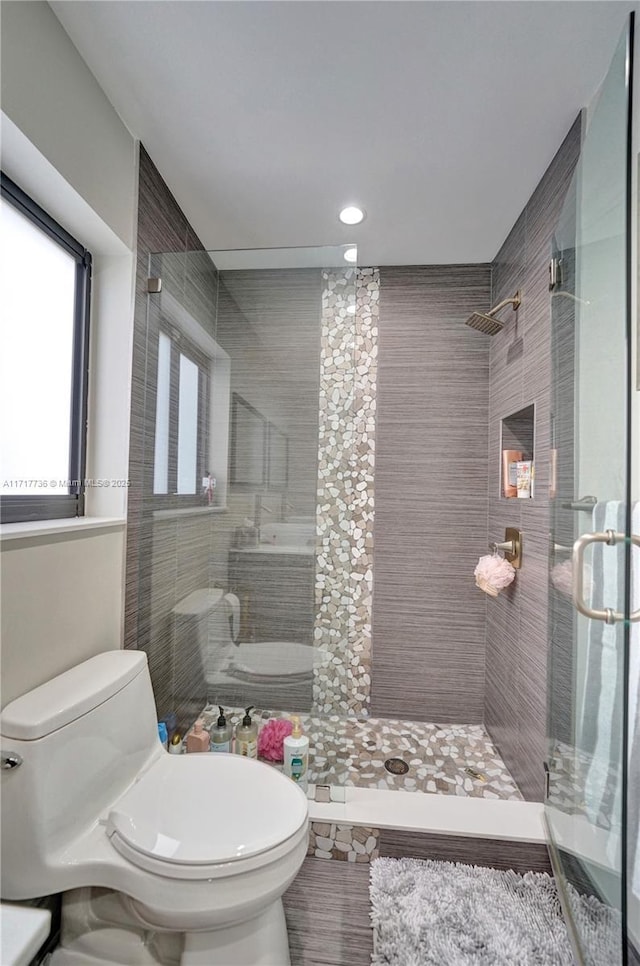 bathroom with tiled shower and toilet