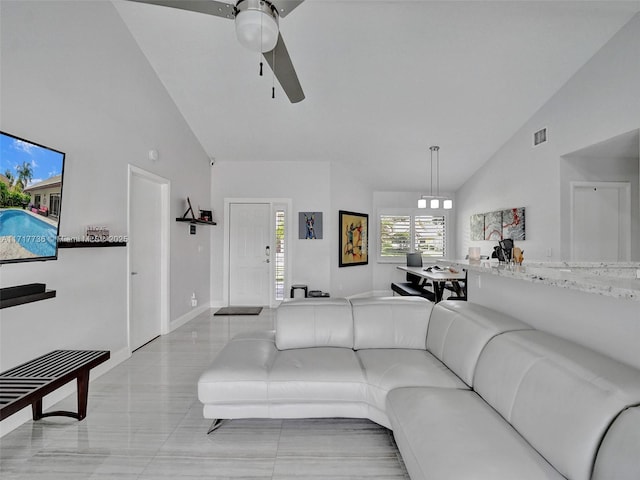 tiled living room featuring ceiling fan and high vaulted ceiling