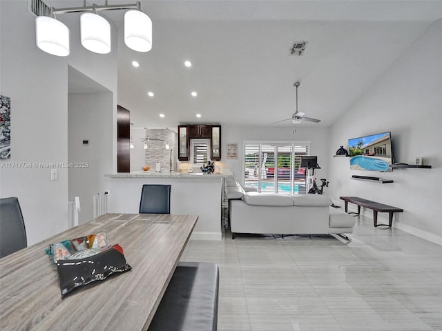 dining area featuring ceiling fan, light tile patterned floors, and vaulted ceiling