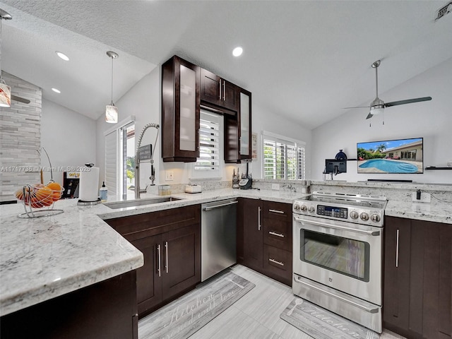 kitchen with stainless steel appliances, vaulted ceiling, hanging light fixtures, and sink