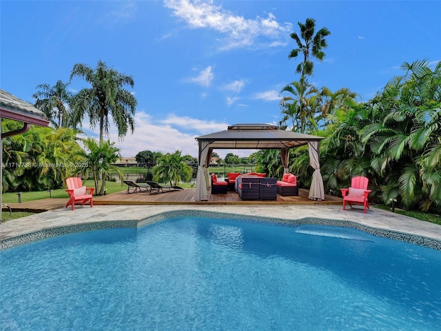 view of pool featuring outdoor lounge area, a gazebo, and a wooden deck