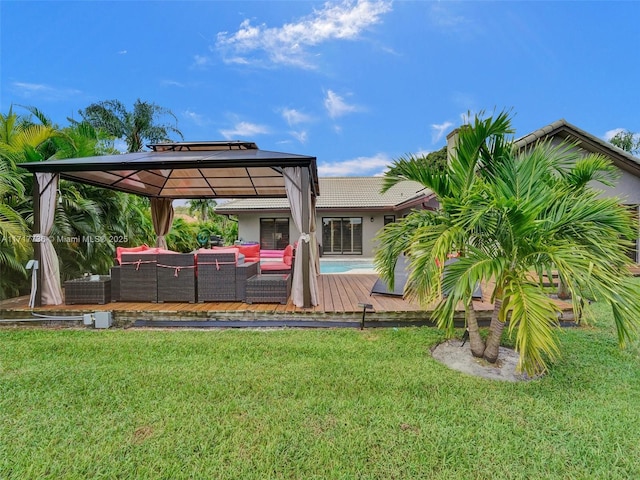 exterior space featuring a gazebo, an outdoor living space, a deck, and a lawn