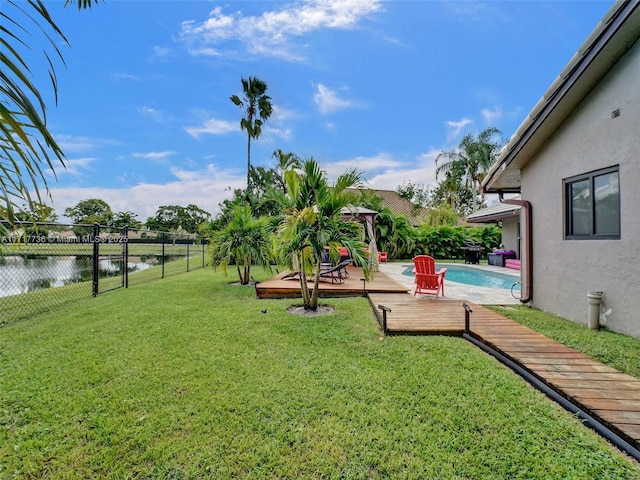 view of yard featuring a pool side deck with water view