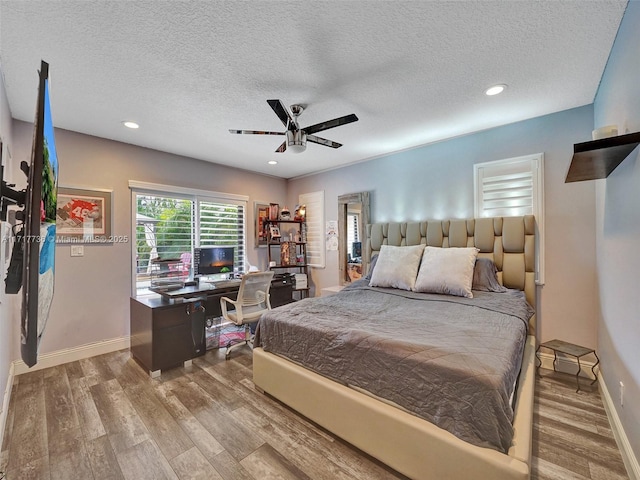 bedroom with ceiling fan, a textured ceiling, and light hardwood / wood-style flooring