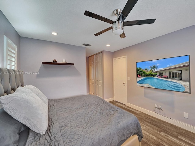 bedroom featuring ceiling fan, a closet, and hardwood / wood-style floors