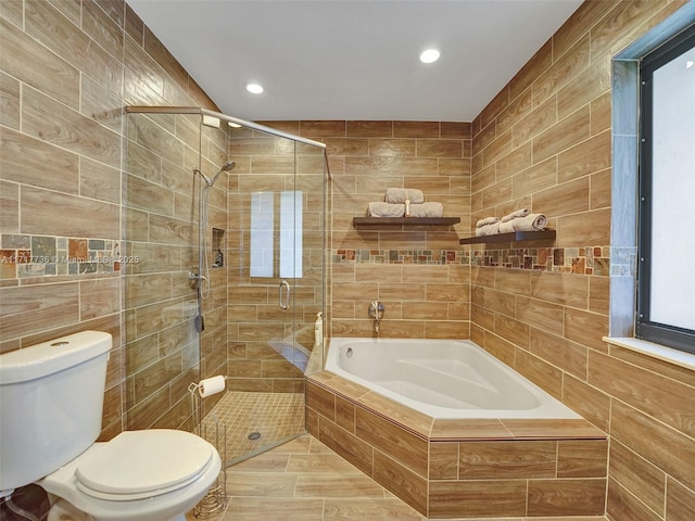 bathroom with toilet, tile patterned flooring, separate shower and tub, and tile walls