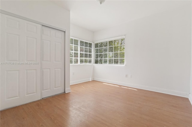 unfurnished bedroom featuring a closet and light wood-type flooring