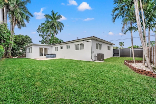 back of property with a patio, a lawn, and central air condition unit