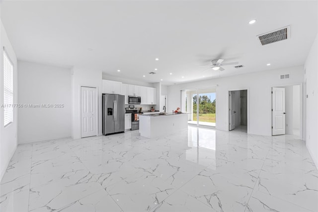 kitchen featuring sink, ceiling fan, a kitchen island, white cabinetry, and stainless steel appliances